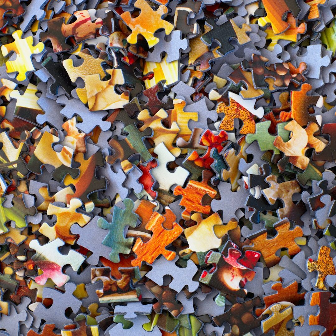 Image shows a pile of jigsaw puzzle pieces